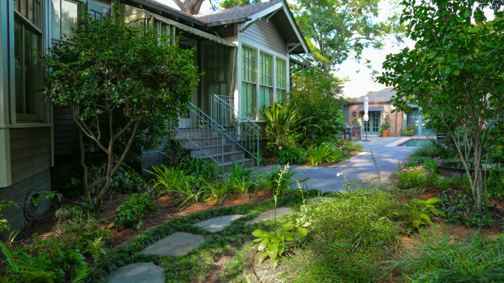 Brick-edged garden path beside a home in an Old Metairie backyard renovation