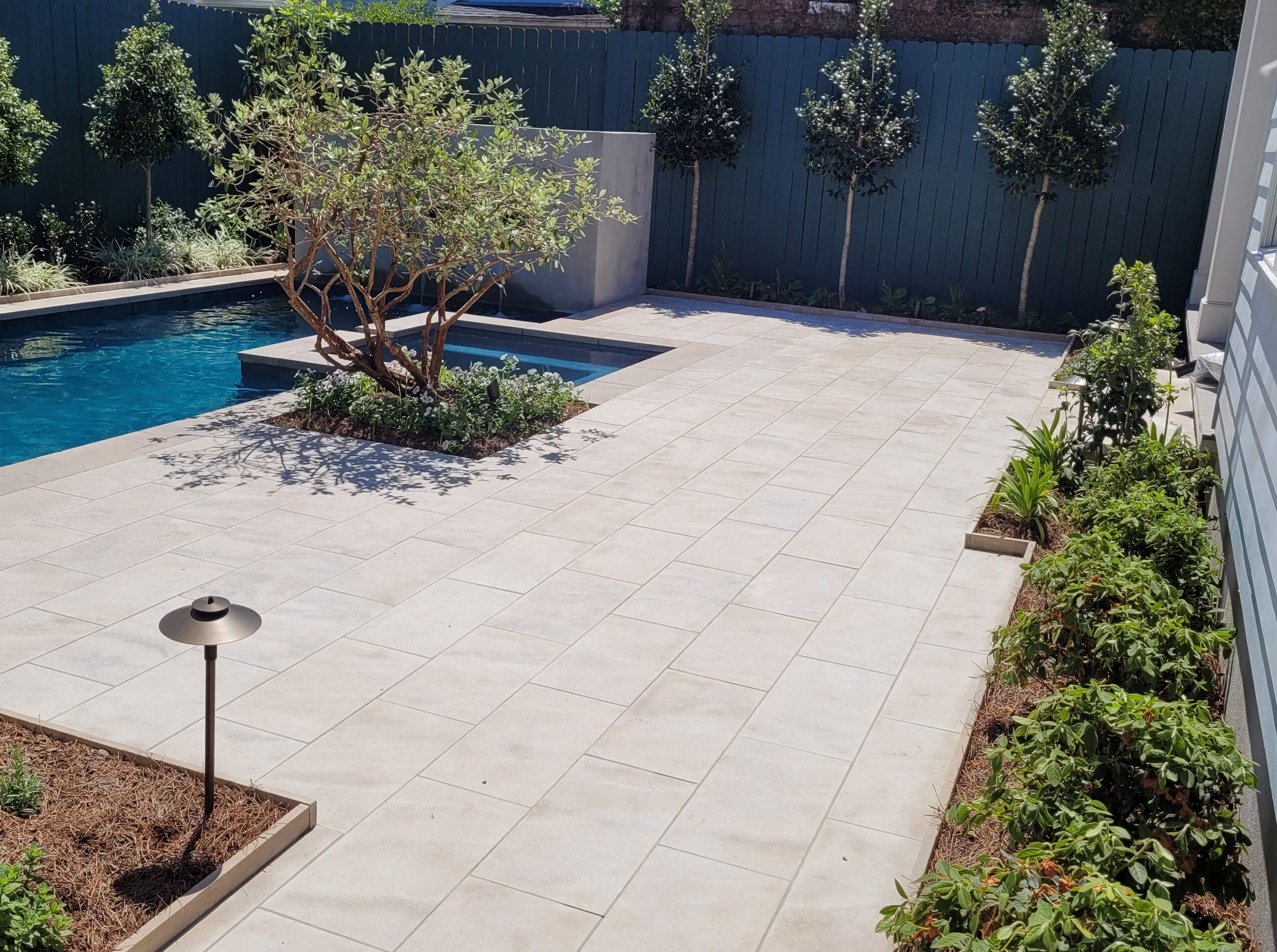 Newly installed planting and low-voltage landscape lighting beside the pool terrace at the Webster Street garden in 2023.