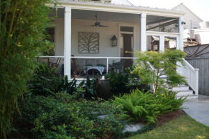 Ceramic water feature surrounded by bamboo, ferns, and mature foliage in an Uptown New Orleans garden