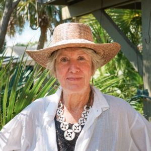 Landscape architect Marianne Mumford standing among tropical plantings in a New Orleans garden.