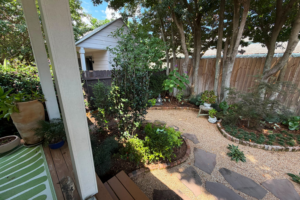 Constance Street Garden in Uptown New Orleans with flagstone steppers set in crushed brownstone, curved brick edging, and layered planting beneath mature trees.